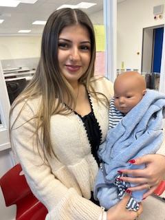 Eine Schülerin hält ein Babypuppen-Modell